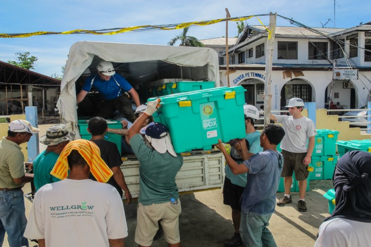 Workers load emergency shelter supplies onto a truck.