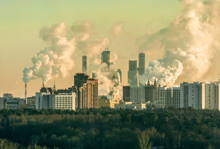 City with pollution from smokestacks impacting the environment.