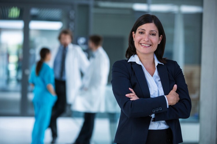 A healthcare administrator stands with arms crossed