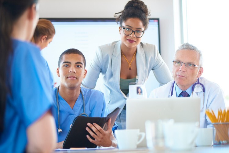 A hospital administrator meets with colleagues.