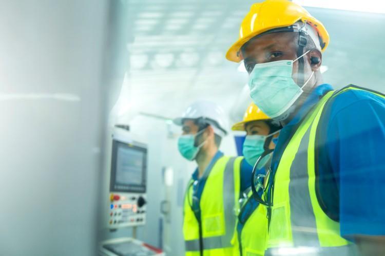 Three industrial hygienists work in a building’s mechanical room.