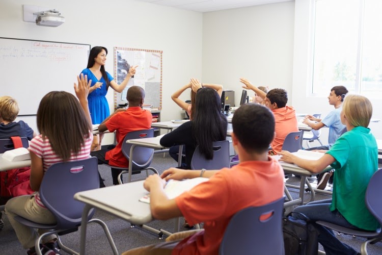 A teacher calls on students in a bilingual high school classroom.