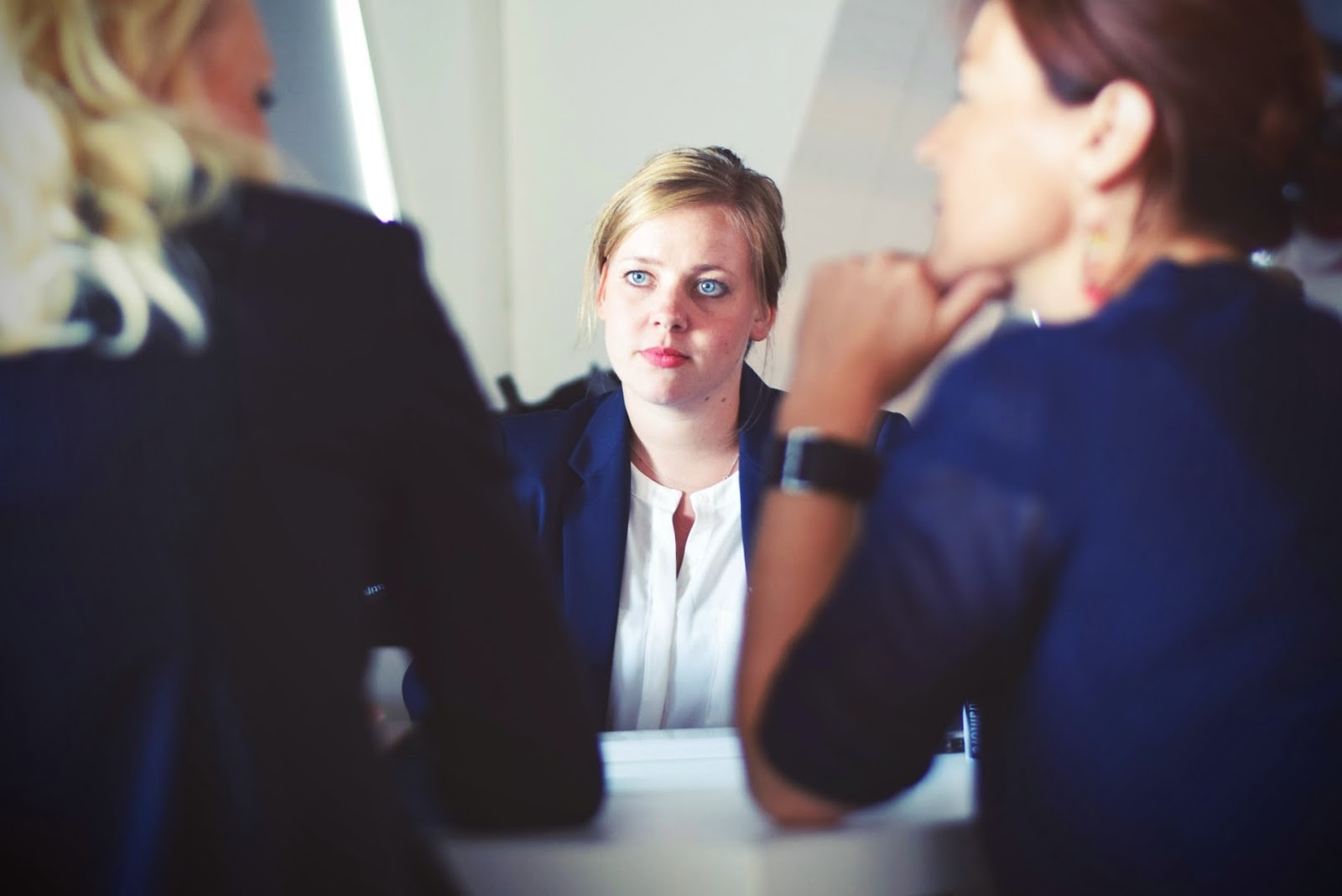 Three businesswomen have a conversation.